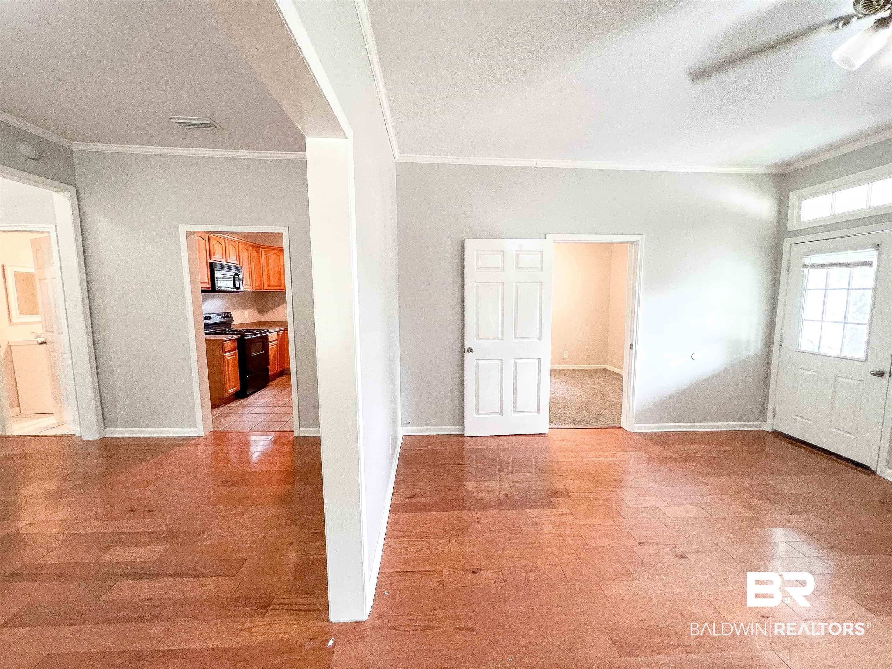 1164 Seneca Street Mobile, AL 36605 - Photo 6 of 22 Empty room featuring light wood-style floors, baseboards, and crown molding