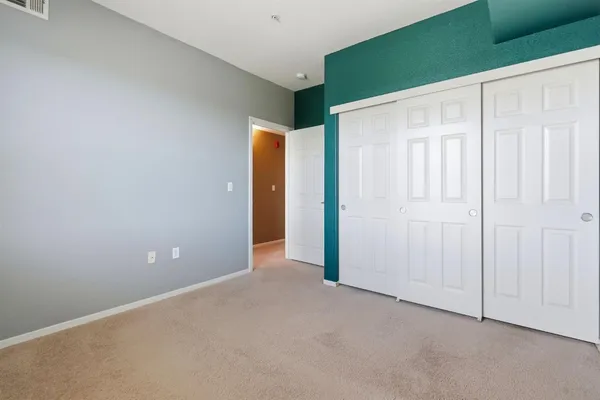 an empty room with closet and a bathroom
