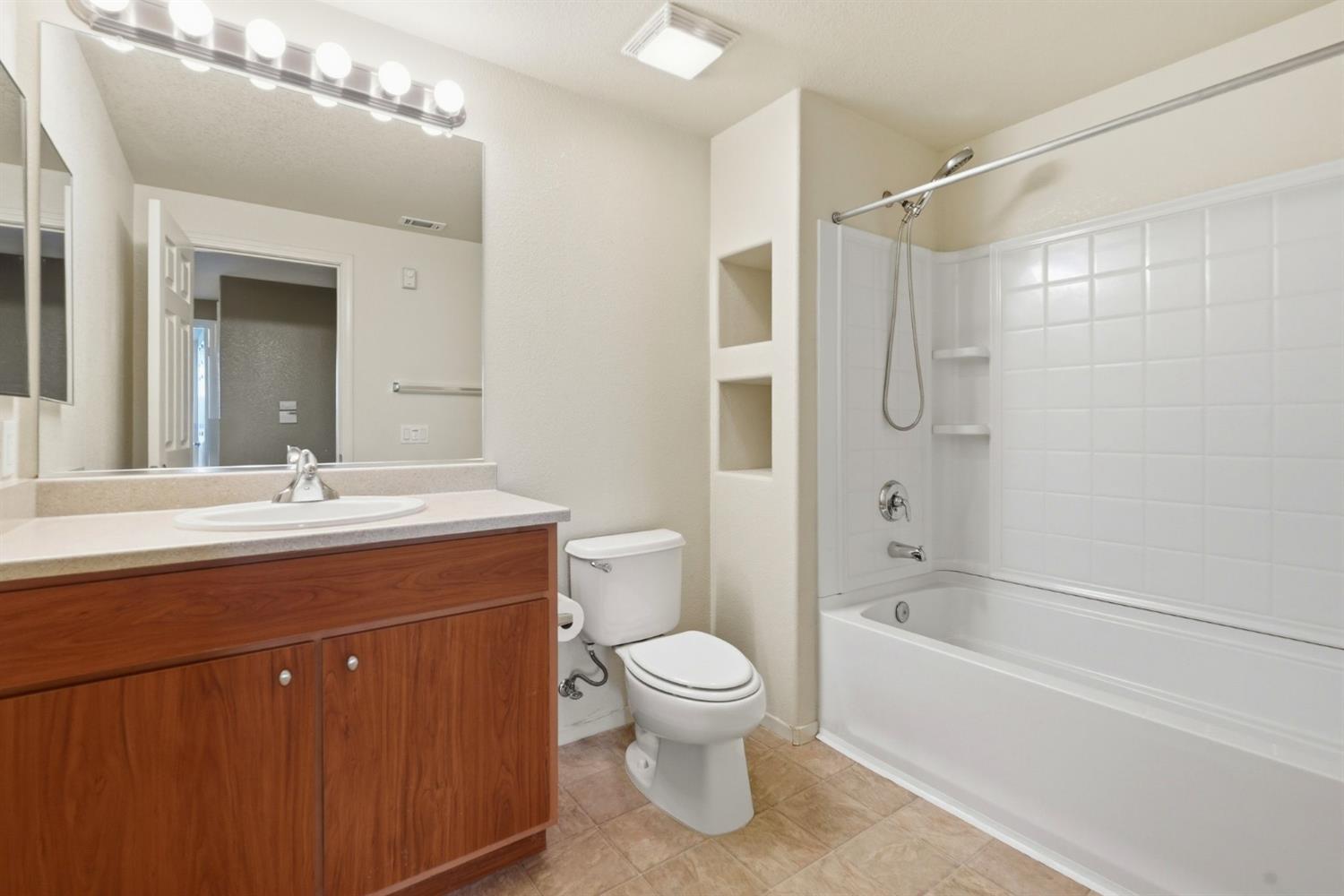 1240 Whitney Ranch Parkway, Unit PW338 Rocklin, CA 95765 - Photo 30 of 58 a bathroom with a bathtub shower sink vanity mirror and toilet