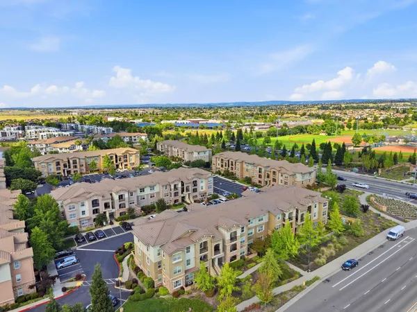 an aerial view of a residential houses with yard