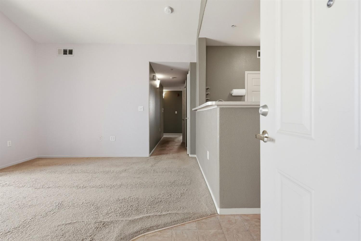 1240 Whitney Ranch Parkway, Unit PW338 Rocklin, CA 95765 - Photo 6 of 58 a view of a hallway with a white cabinet and a refrigerator