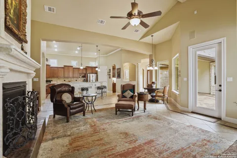 a living room with furniture a fireplace and a chandelier