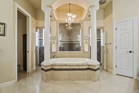 a bathroom with a tub a double vanity sink and mirror