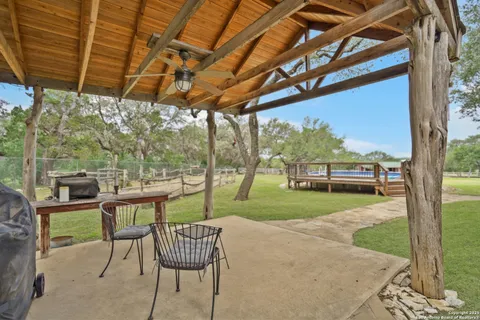 a view of a swimming pool with lawn chairs and a big yard