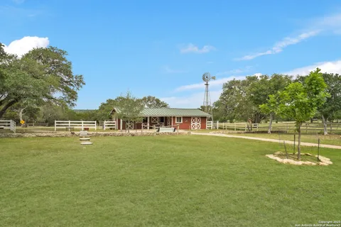 a front view of a house with a garden and trees