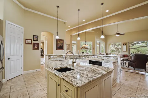 a kitchen with a stove a refrigerator a sink and living room view