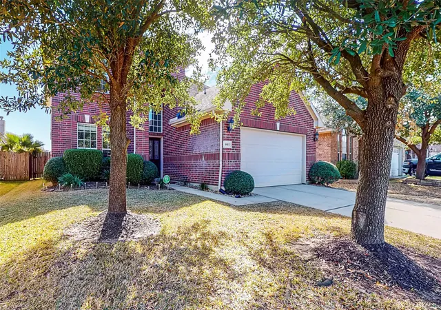 a view of a house with backyard and a tree