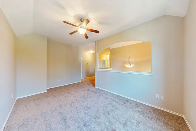 an empty room with windows and ceiling fan