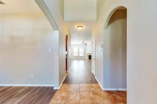 a view of a hallway to a bedroom with wooden floor and a bathroom