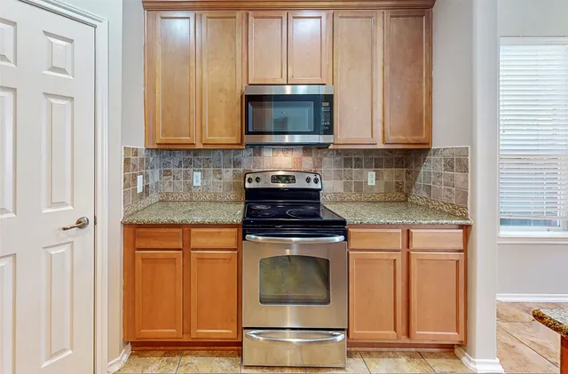 a kitchen with granite countertop a stove and a microwave