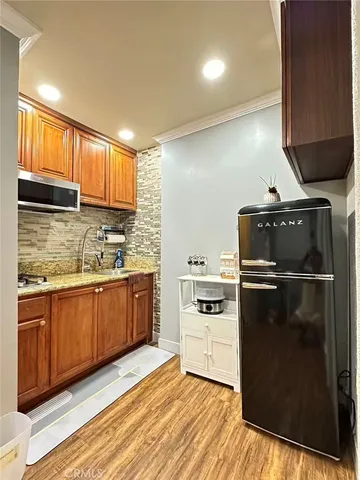 a kitchen with a refrigerator sink and wooden cabinets