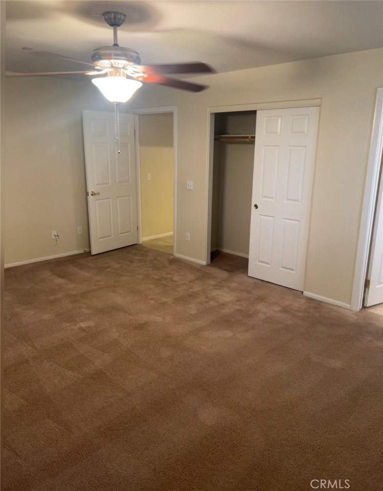 32636 Sapphire Road Lucerne Valley, CA 92356 - Photo 11 of 19 an empty room with chandelier fan and kitchen view