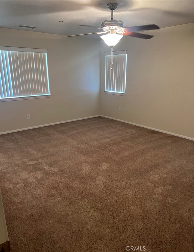 32636 Sapphire Road Lucerne Valley, CA 92356 - Photo 13 of 19 an empty room with a chandelier fan and windows
