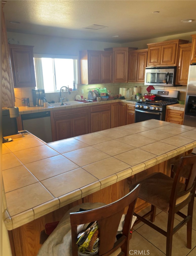32636 Sapphire Road Lucerne Valley, CA 92356 - Photo 14 of 19 a kitchen with kitchen island granite countertop wooden cabinets a counter top space a sink and appliances