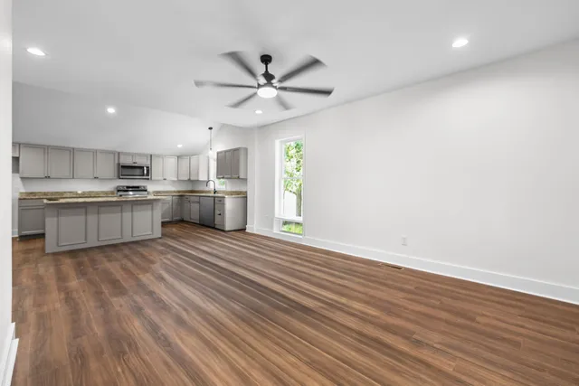 a kitchen with stainless steel appliances granite countertop wooden cabinets and a sink