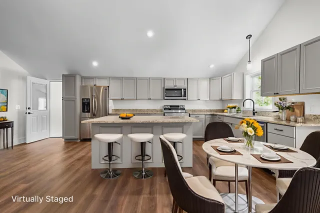 a kitchen with stainless steel appliances granite countertop a stove a sink and a refrigerator