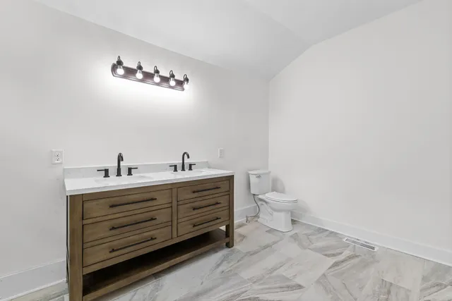 a bathroom with a granite countertop sink toilet and bathtub