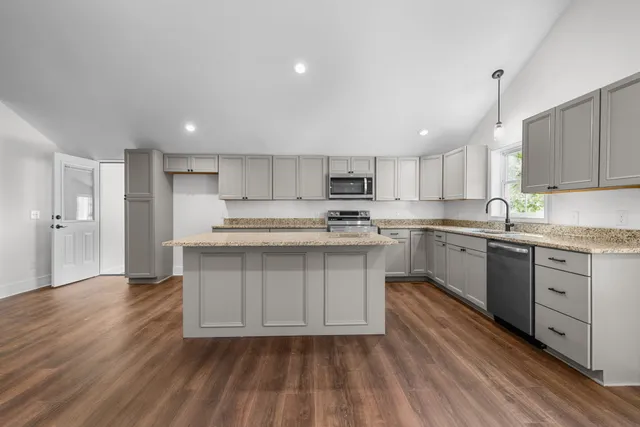 a kitchen with stainless steel appliances granite countertop a sink stove and refrigerator