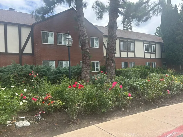 a view of a house that has a flower garden
