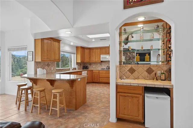 a large kitchen with stainless steel appliances granite countertop a refrigerator a sink dishwasher a oven with granite countertops and cabinets