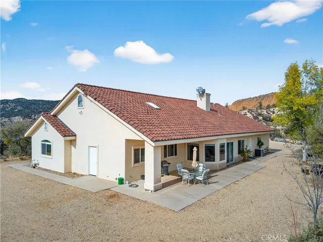 an aerial view of a house with a mountain