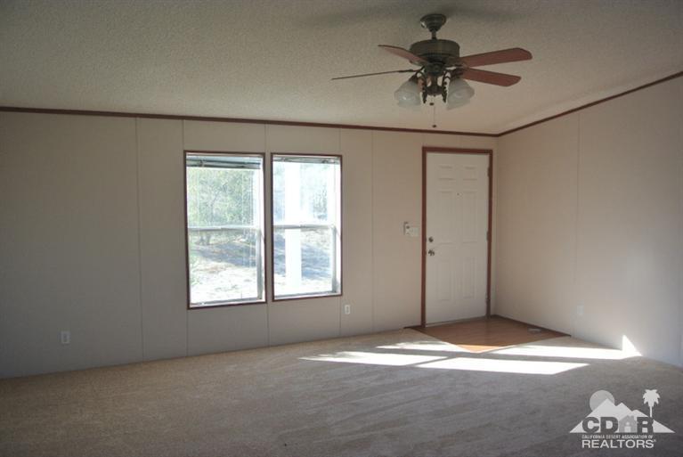 15488 Desert View Road Whitewater, CA 92282 - Photo 4 of 19 an empty room with a ceiling fan and window