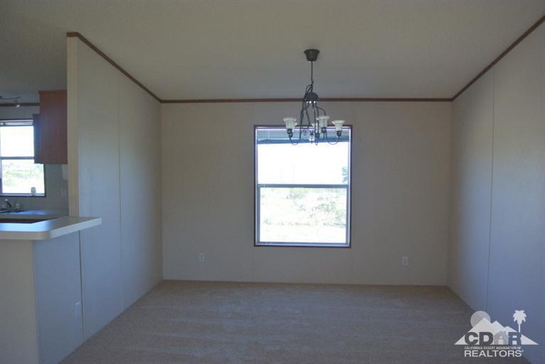 15488 Desert View Road Whitewater, CA 92282 - Photo 6 of 19 an empty room that has a window and a chandelier