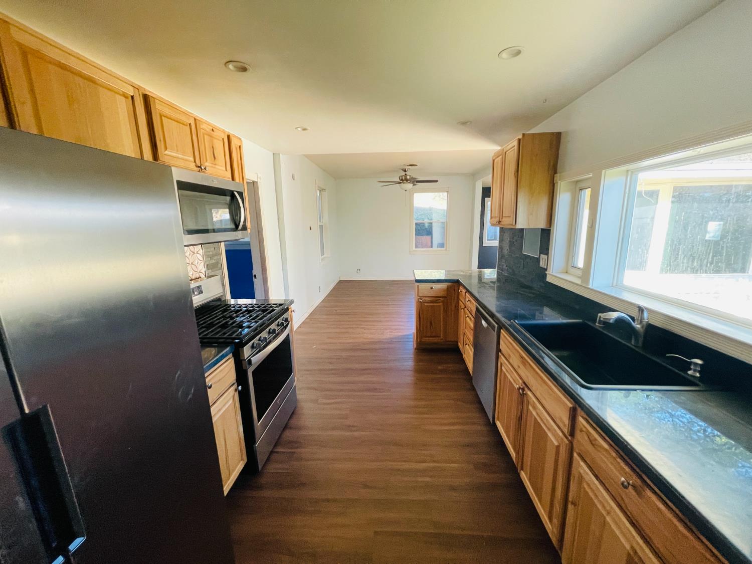 210 South Summit Street Ione, CA 95640 - Photo 21 of 27 a kitchen with granite countertop a refrigerator a stove and a sink