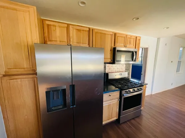 a kitchen with stainless steel appliances wooden cabinets and a refrigerator