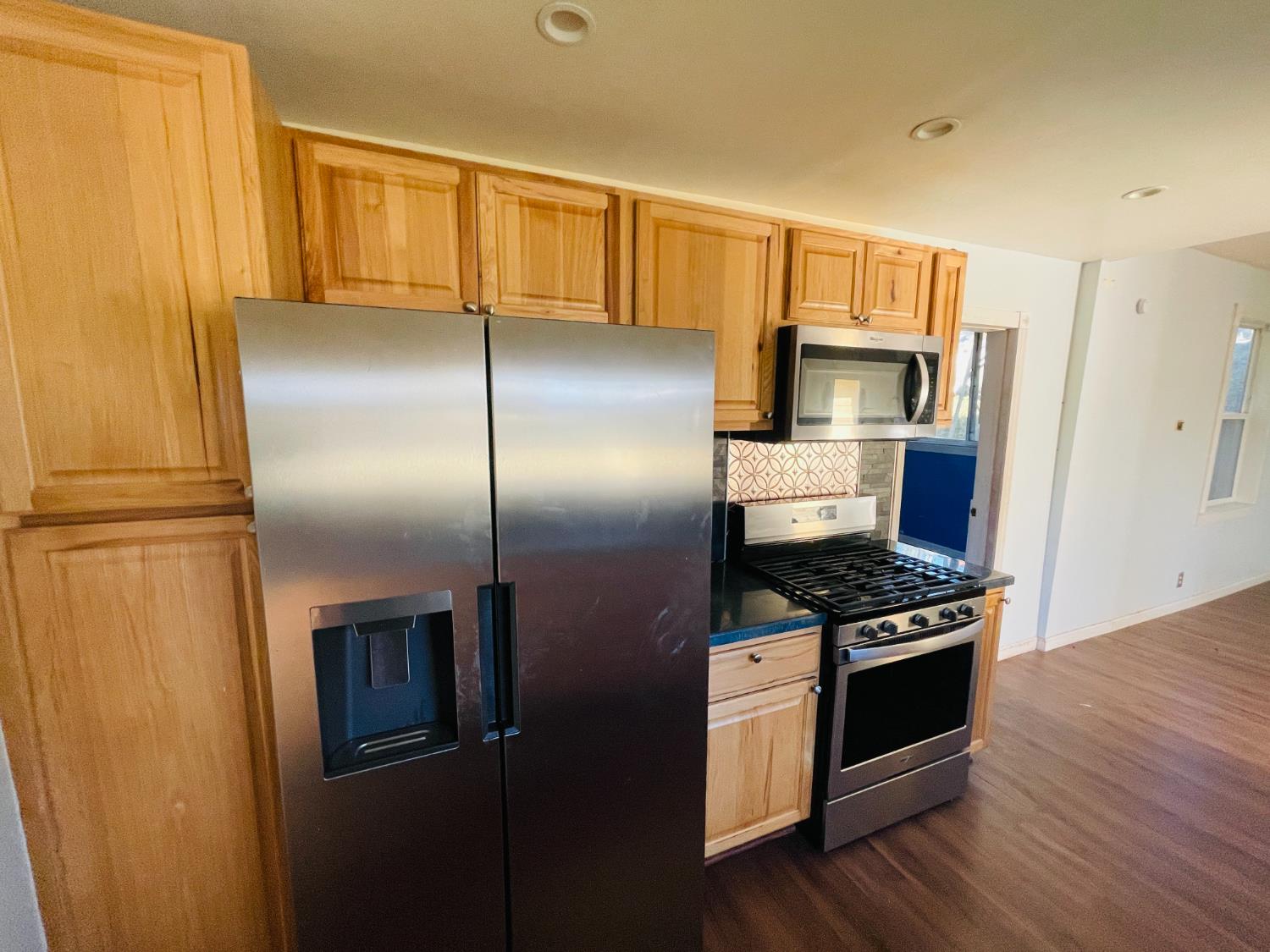 210 South Summit Street Ione, CA 95640 - Photo 22 of 27 a kitchen with stainless steel appliances wooden cabinets and a refrigerator