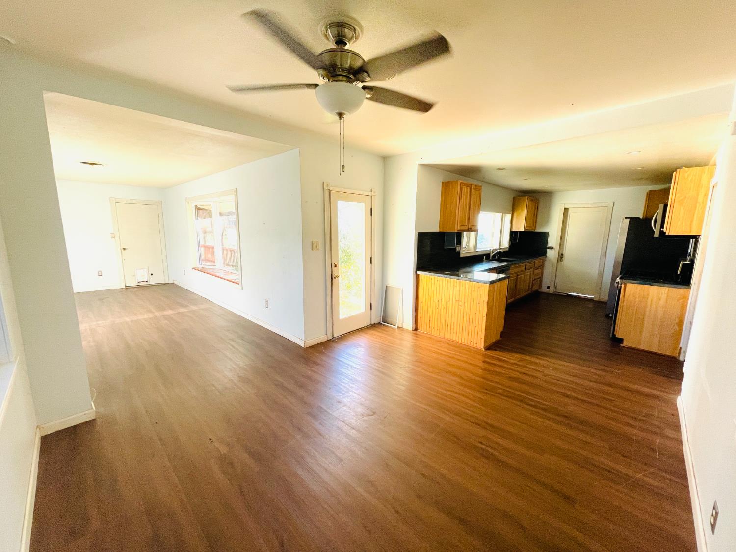 210 South Summit Street Ione, CA 95640 - Photo 25 of 27 a view of a living room a dining room with wooden floor and a chandelier fan