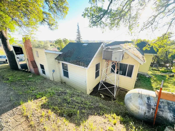 a aerial view of a house with backyard and trees