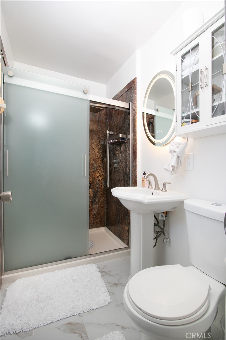 1034 Thompson Avenue Banning, CA 92220 - Photo 13 of 24 a bathroom with a sink a mirror a toilet and a mirror