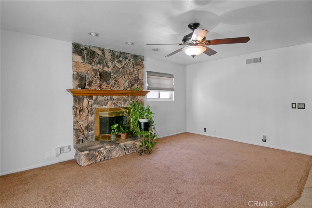1034 Thompson Avenue Banning, CA 92220 - Photo 3 of 24 a view of a livingroom with a fireplace and a chandelier fan
