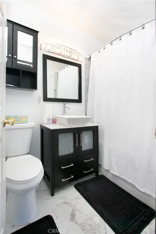 a bathroom with a toilet a sink and a mirror