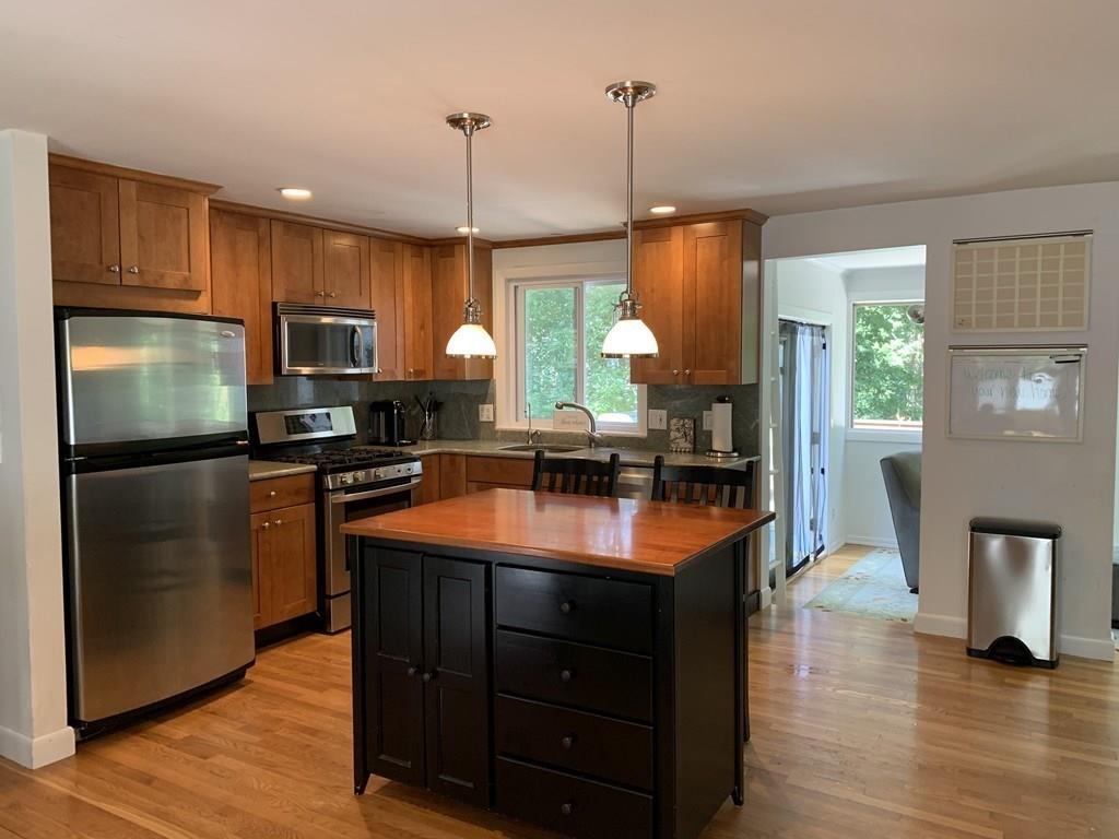 158 Tilden Road Scituate, MA 02066 - Photo 9 of 33 a kitchen with stainless steel appliances granite countertop wooden floor sink stove and refrigerator