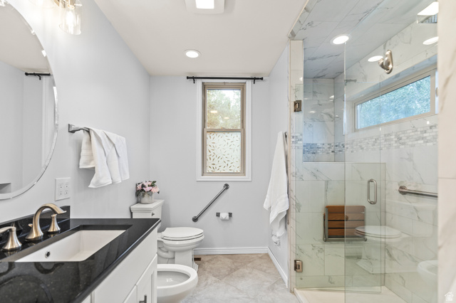 460 Omni Point Road Central Valley, UT 84754 - Photo 40 of 101 Bathroom featuring a dark stone countertop vanity with an undermount sink, a toilet, and a bidet