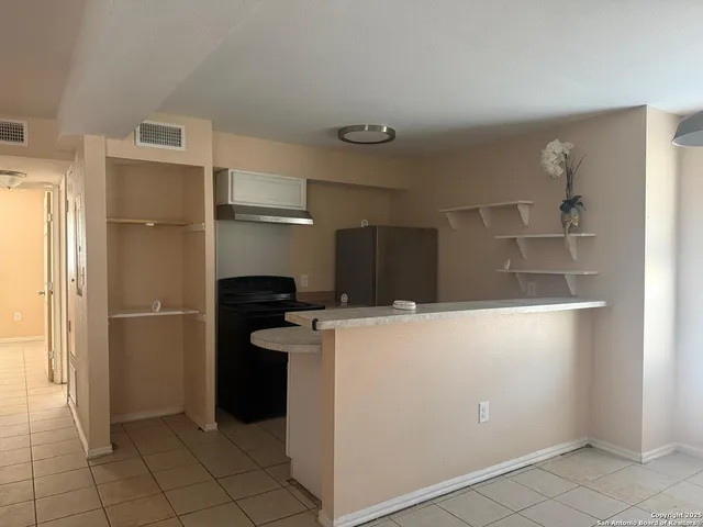 a kitchen with a refrigerator and a stove top oven