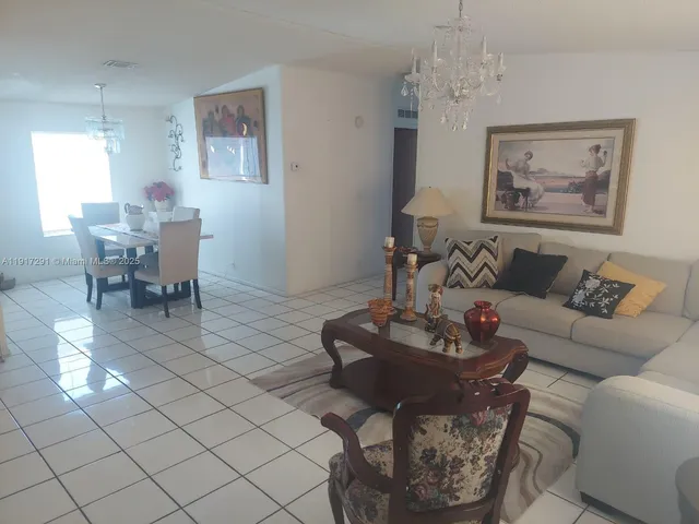 a living room with furniture a dining table and a painting on the wall