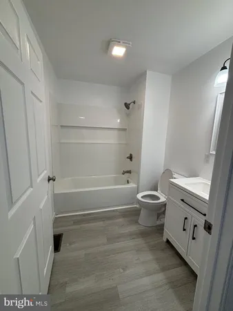 a bathroom with a toilet a sink a tub and mirror