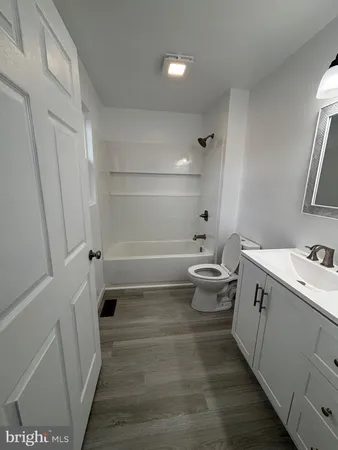 a bathroom with a toilet sink vanity tub and mirror