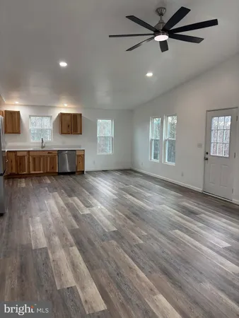 a living room with stainless steel appliances kitchen island a refrigerator sink and cabinets