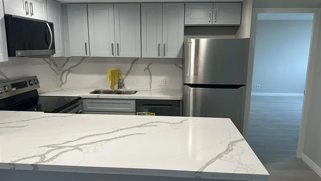 a kitchen with a refrigerator and a stove top oven