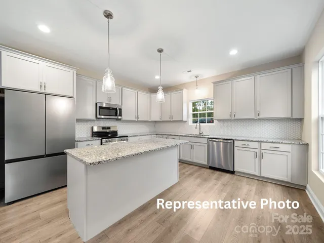 a large kitchen with kitchen island a sink stainless steel appliances and cabinets