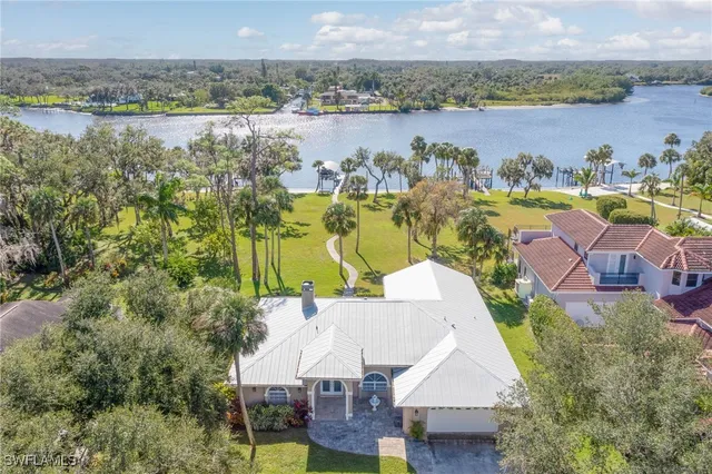 an aerial view of residential houses with outdoor space and lake view