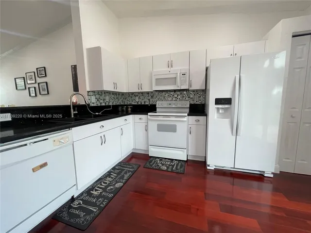 a kitchen with granite countertop a sink and cabinets