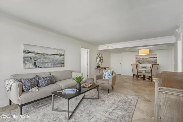 a living room with furniture and a dining table with rug