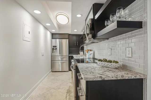 a kitchen with stainless steel appliances granite countertop a sink and a refrigerator