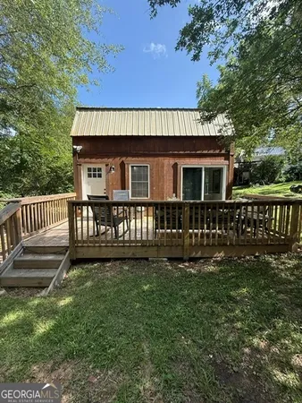 a view of a house with wooden deck and a yard