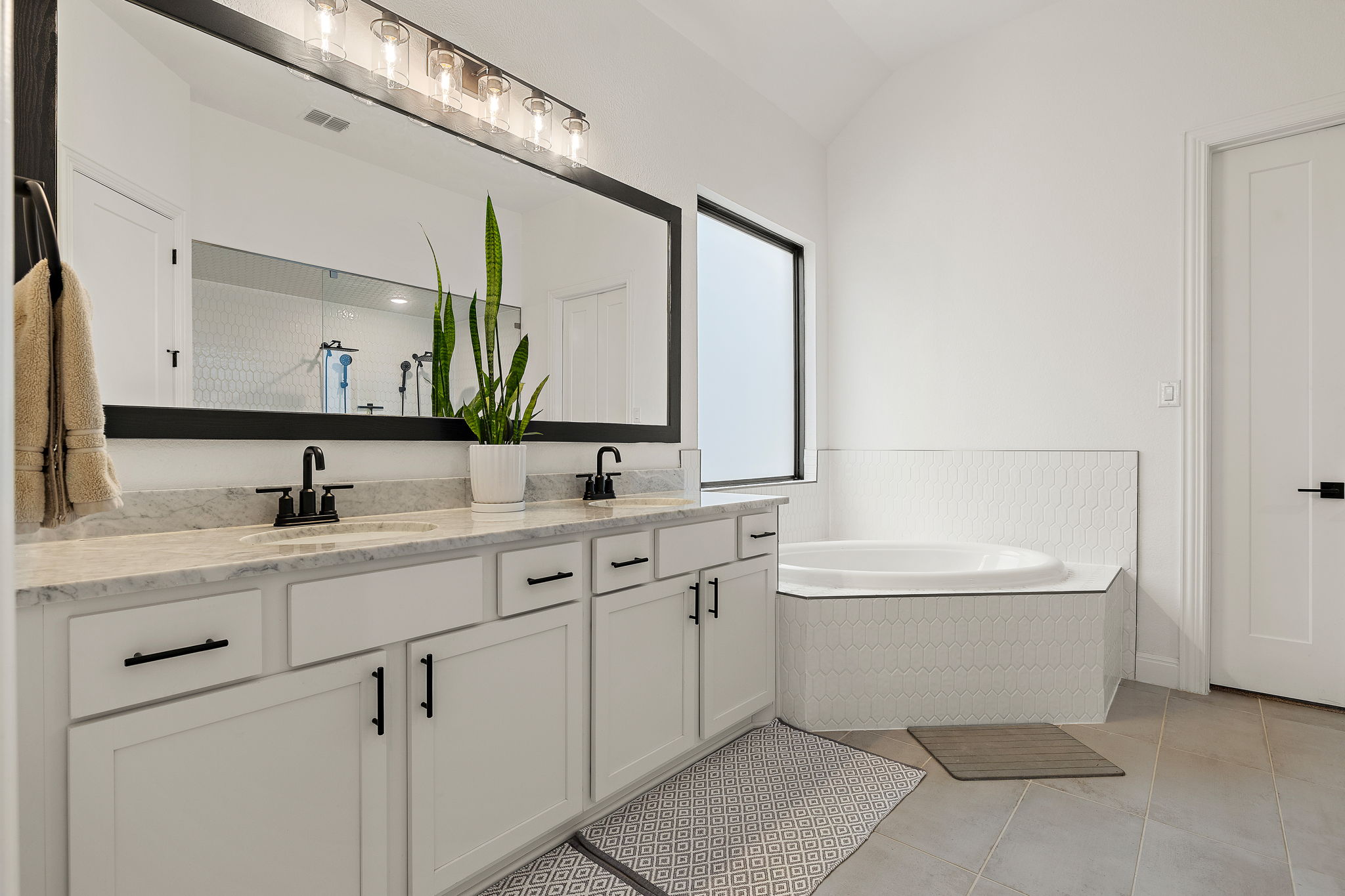 181 Constitution Way Kyle, TX 78640 - Photo 20 of 32 a bathroom with a double vanity sink a mirror and a bathtub